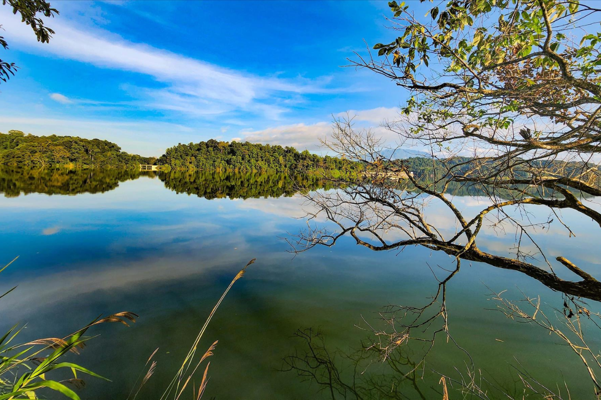 Clear reflections of sky and mountains on the still waters of Pa Khoang Lake